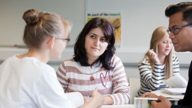 Three students having a conversation together